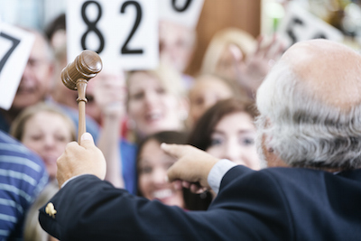 Auctioneer with Large Crowd of Buyers