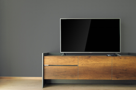 Led TV on TV stand with black wall